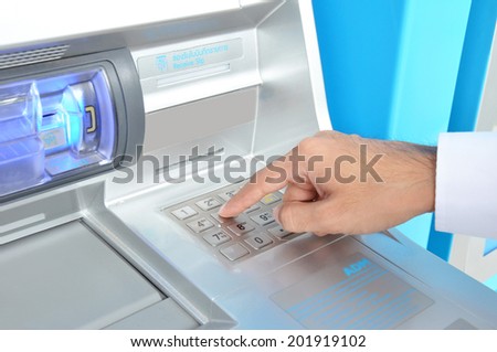 ATM (or Automated Teller Machine ) with hand pressing on the keypad
