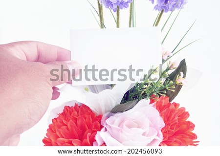 Hand holding empty tag card on flower bouquet - retro style lighting effect