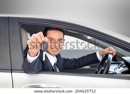 Asian businessman showing a car key - car sale & rental business concept