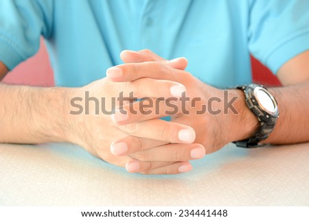 A man sitting with clasped hands on the table