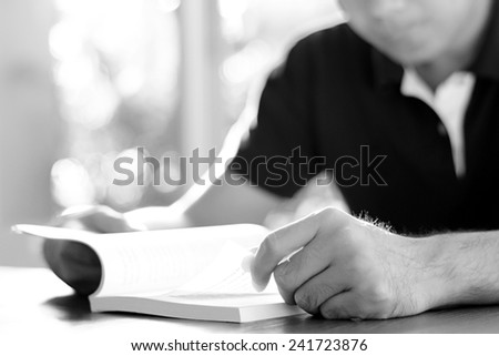 A man reading book on the table - studying & exam concept