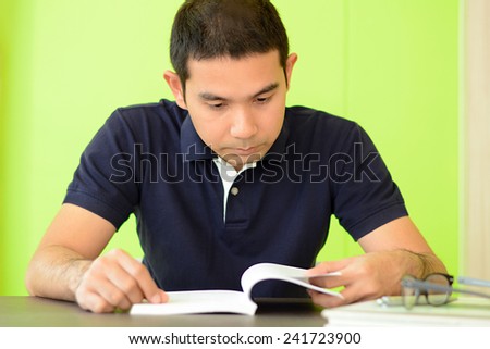 A man reading book on the table - studying & exam concept