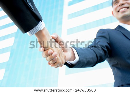 Handshake of businessmen with smiling face - greeting, dealing, partnership, merger & acquisition concepts