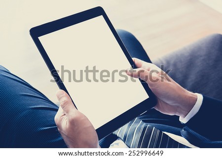 Businessman hands holding tablet pc with isolated screen - vintage (retro) style color effect