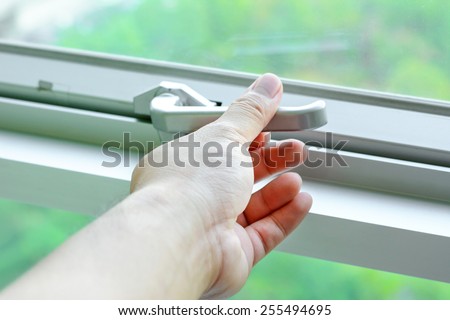 Hand holding glass window latch handle
