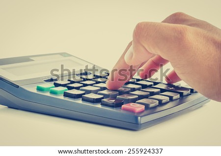 Fingers pressing on calculator keypad - vintage (retro) color effect