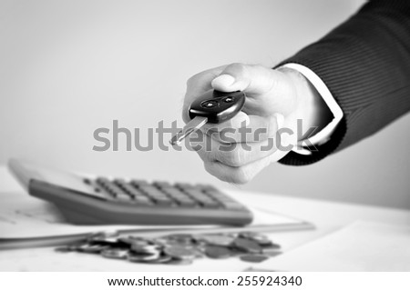 Businessman hand giving a car key, car rental & pawn concepts - black & white tone