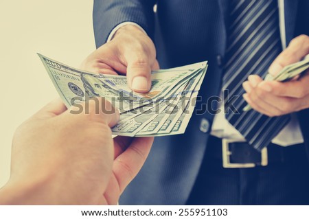 Hand receiving money, US dollars,  from business man - vintage (retro) style color effect