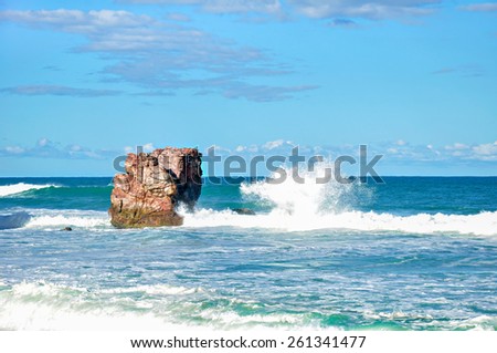 Wave crashing rocks at the beach