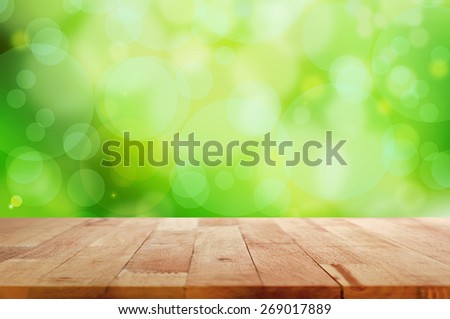 Wood table top on green bokeh abstract background - can be used for montage or display your products