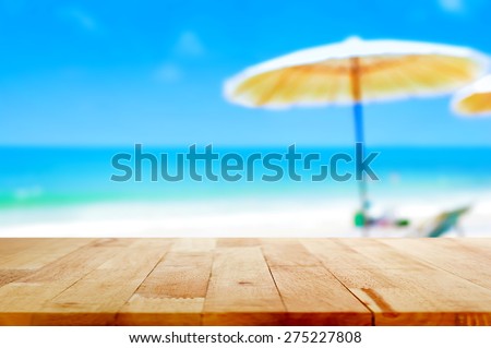 Wood table top on blurred blue sea and white sand beach background - can be used for display or montage your products