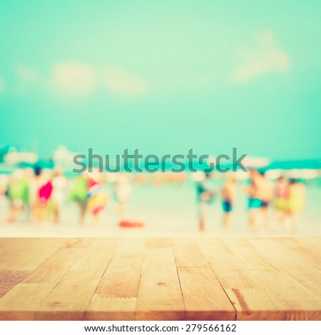 Wood table top with blurred people at the beach as background, vintage tone - can be used for display or montage your products