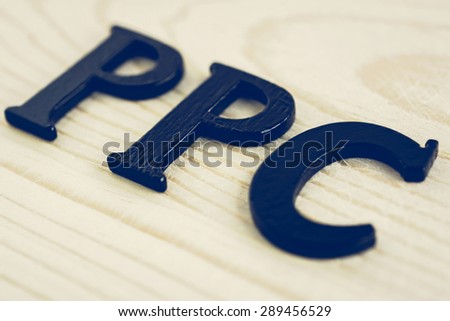 PPC (or Pay Per Click) sign on wood background, internet (online) marketing and advertising concepts - vintage tone