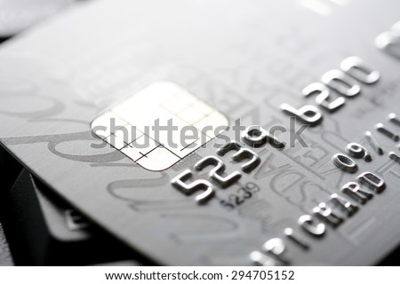 Close up of credit card with chip and numbers, gray and silver theme