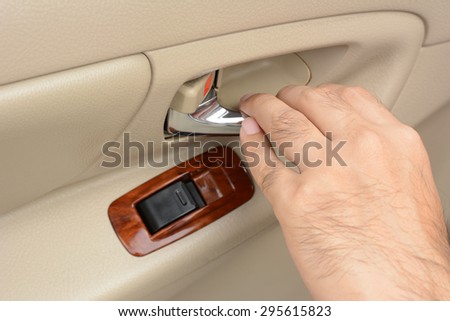 Hand pulling car interior door handle, opening car door
