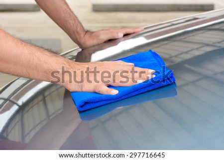 Hand polishing car bonnet with microfiber cloth
