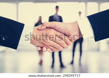 Handshake of businessmen on blur businesspeople background, vintage tone - greeting, dealing, merger and a acquisition concepts
