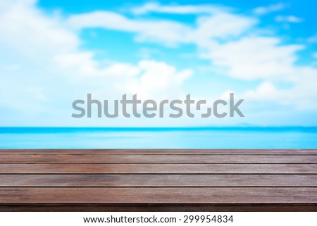 Old brown wood table top on blur sea and summer sky background - can be used for display and montage your products