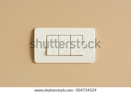 Triple light switches on colored concrete wall