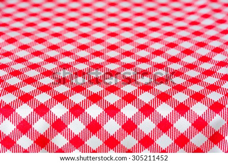 Table covered with red checkered picnic tablecloth - can be used as background for montage food and products