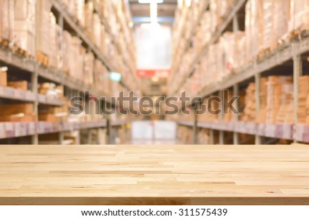 Empty wood table top on blurred warehouse background - can montage or display your products