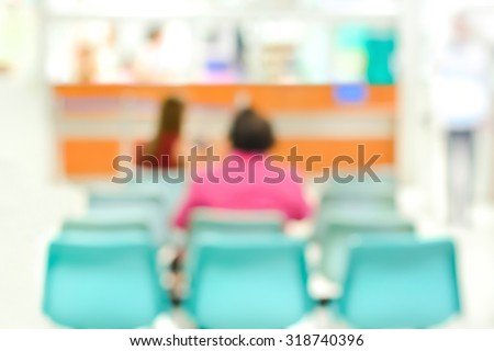 Blurred back view of people sitting in hospital lobby, for background