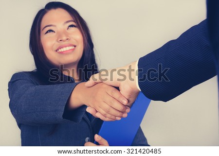 Young Asian businesswoman making handshake, vintage tone