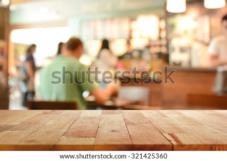 Wood table top on blur background of coffee shop interior with some people - can be used for display or montage your products