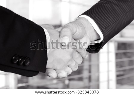 Handshake of businessmen in black and white tone - greeting, dealing, mergers and acquisition concept