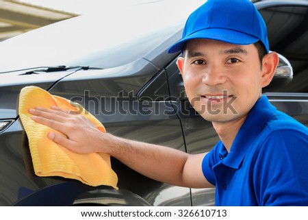 A man with smiling face cleaning car