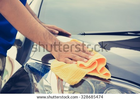 A man cleaning car with microfiber cloth, vintage tone image