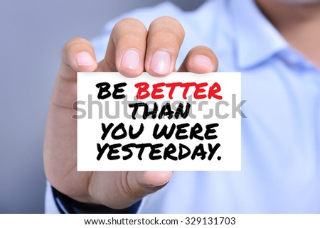 BE BETTER THAN YOU WERE YESTERDAY, message on the card shown by a man