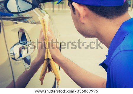 A man polishing car with microfiber cloth, car detailing (or valeting) concept, vintage tone image