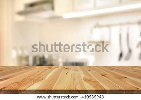 Wood table top (as kitchen island) on blur kitchen interior background - can be used for display or montage your products