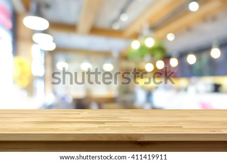 Wood table top on blur background of coffee shop (or restaurant) interior - can be used for display or montage your products