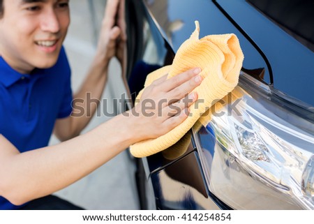 A man polishing (cleaning) car with microfiber cloth, car detailing or valeting concept