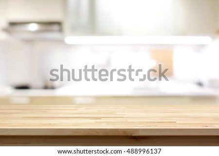 Wood countertop (or kitchen island) on blur kitchen interior background - can be used for display or montage your products