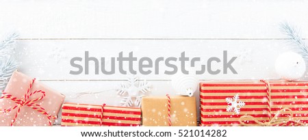 Gift boxes and Christmas ornaments on white wood background, border design panoramic banner