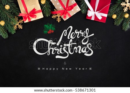 Merry Christmas and Happy New Year text with gift boxes on blackboard background