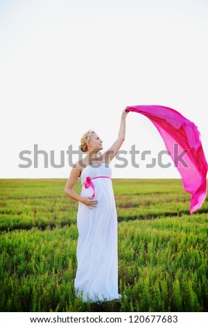young woman in white greek dress  plays with pink cloth