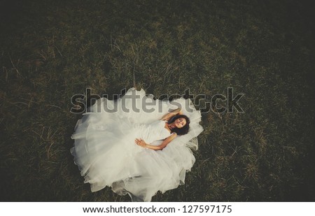 American beauty, bride laying on the grass, high angle shot