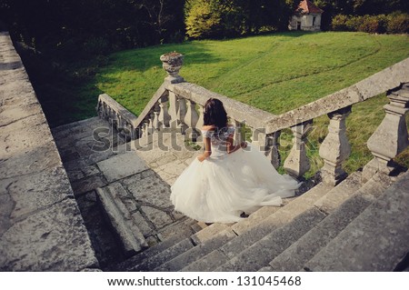 gorgeous bride walks the stairs outdoors