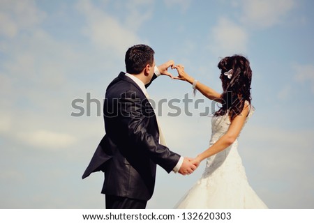 Married Couple holding hands, showing symbol of heart