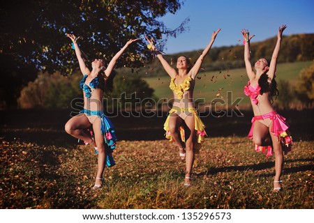 three dancing girls in autumn