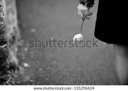 woman holds a tiny tulip, black and white