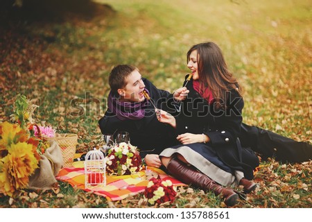 Sweet couple eating candies, having fun in autumn day