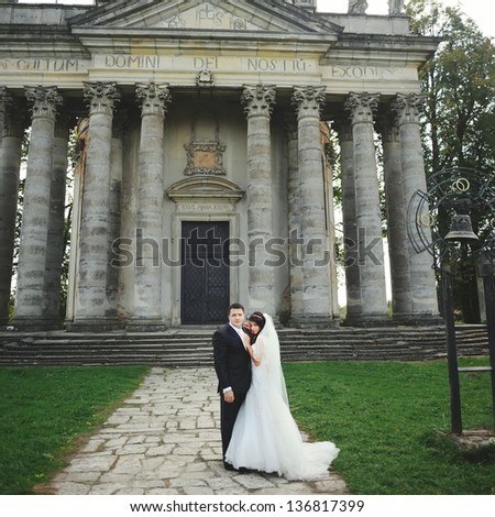 wedding bride and groom, posing next to old church