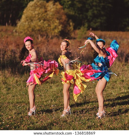 three dancing girls in autumn forest