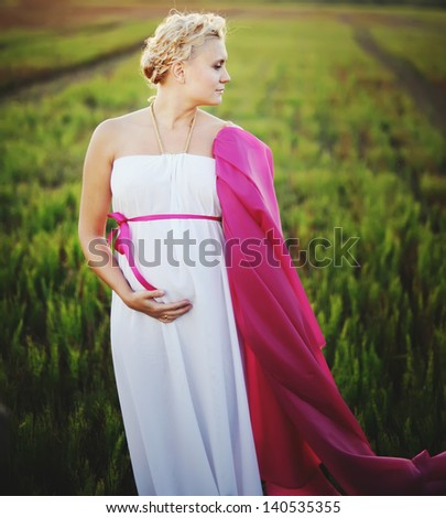 pregnant young woman in greek dress, outside portrait