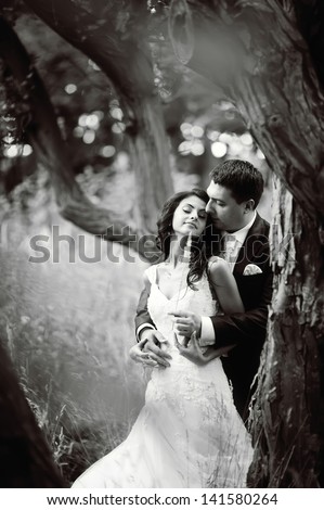Happy wedding couple in forest, black and white